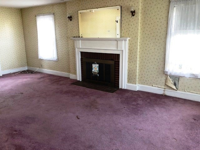165 11th Street Lowell, MA 01850 - Photo 9 of 21 an empty room with a fireplace and windows