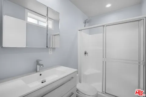 a bathroom with a bathtub shower sink vanity and toilet