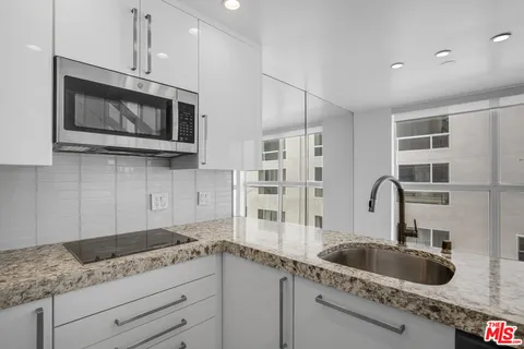 a kitchen with stainless steel appliances granite countertop a sink a microwave and cabinets