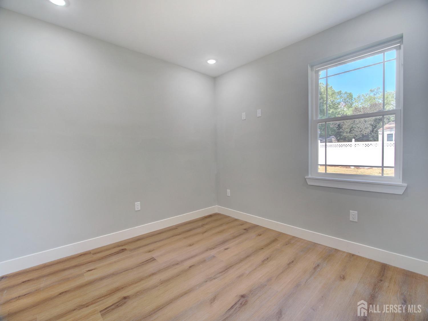 24 Stiles Road Edison, NJ 08817 - Photo 19 of 36 an empty room with wooden floor and windows