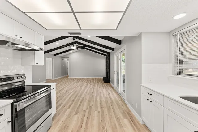 a view of a kitchen with wooden floor and electronic appliances