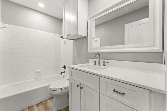 a bathroom with a toilet a sink a bathtub and a vanity