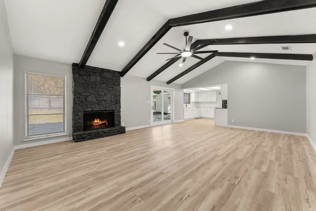 a view of empty room with wooden floor and fireplace