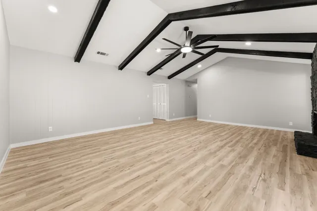 a view of a room with wooden floor and windows