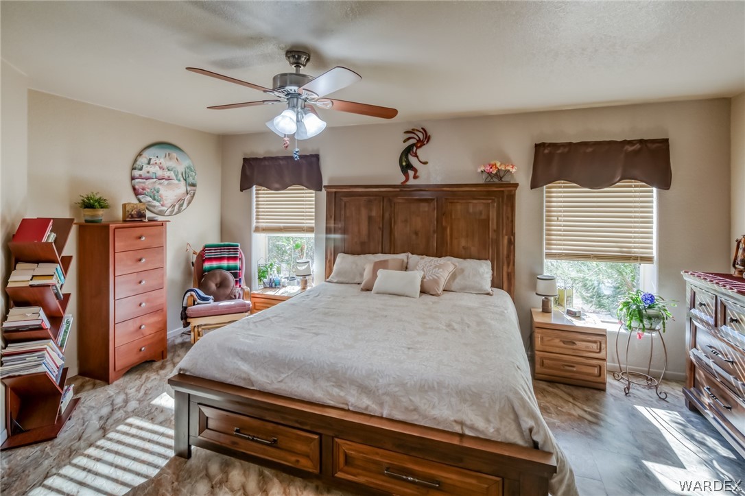 4150 Dragoon Road Golden Valley, AZ 86413 - Photo 23 of 49 a bedroom with a bed a chandelier and dresser