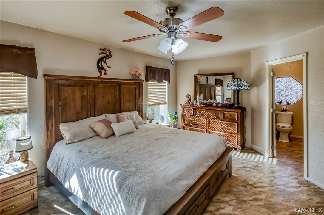 4150 Dragoon Road Golden Valley, AZ 86413 - Photo 24 of 49 a bedroom with a bed ceiling fan and a wooden floor