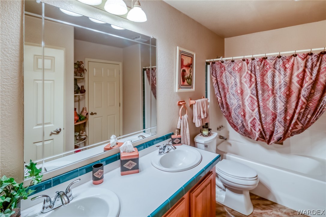 4150 Dragoon Road Golden Valley, AZ 86413 - Photo 30 of 49 a bathroom with a sink a toilet and a mirror
