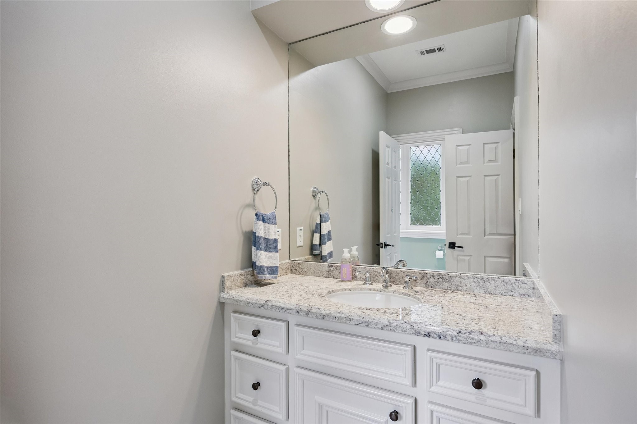 6358 Auden Street Houston, TX 77005 - Photo 29 of 50 a bathroom with a granite countertop sink and a mirror