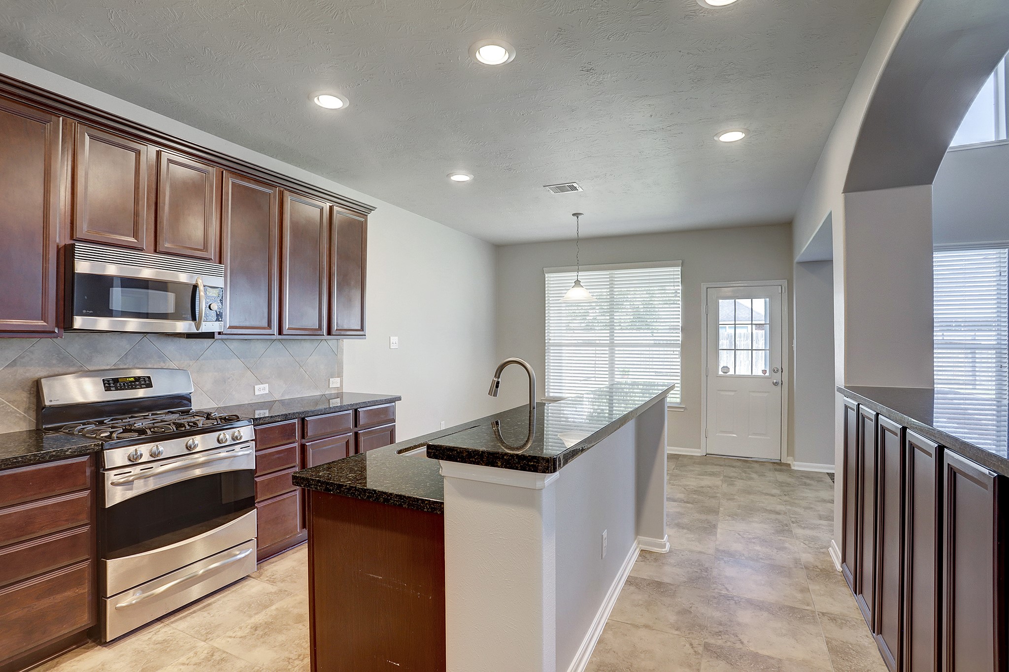12331 Crescent Mountain Lane Humble, TX 77346 - Photo 15 of 34 a kitchen with granite countertop stainless steel appliances a stove sink and cabinets