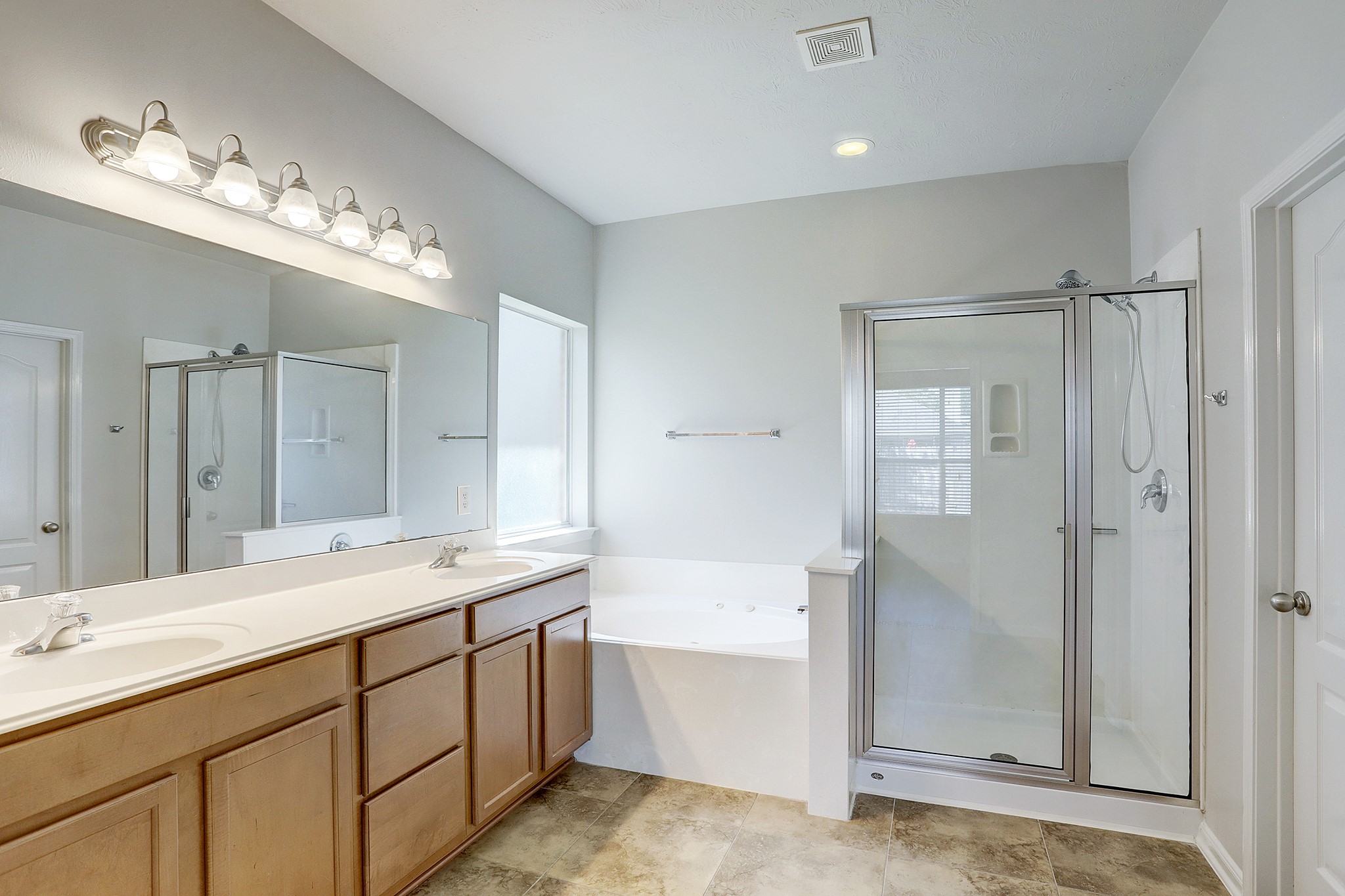 12331 Crescent Mountain Lane Humble, TX 77346 - Photo 21 of 34 a spacious bathroom with a shower a sink and a mirror
