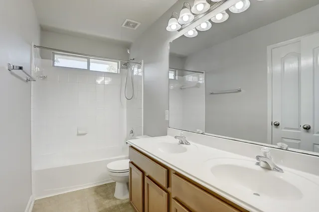 a bathroom with a sink a toilet a mirror and shower