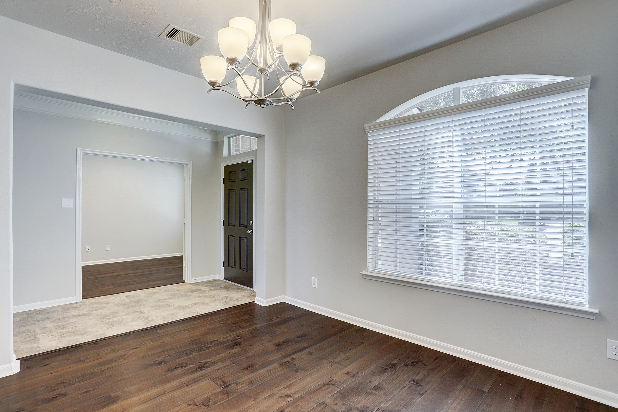 12331 Crescent Mountain Lane Humble, TX 77346 - Photo 10 of 34 a view of an empty room with wooden floor and a window