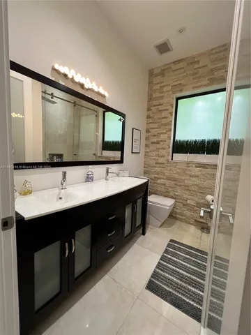 a bathroom with a double vanity sink and mirror