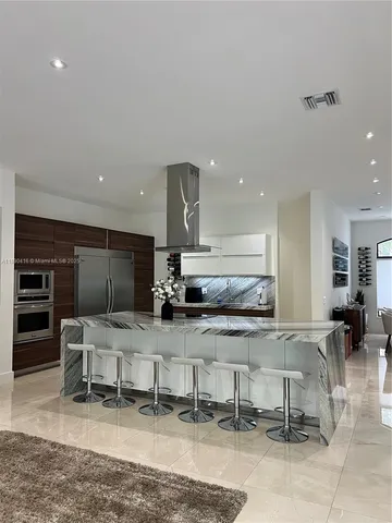 a large kitchen with a large counter top stainless steel appliances and cabinets