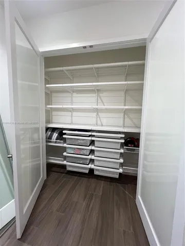 a view of walk in closet with empty racks