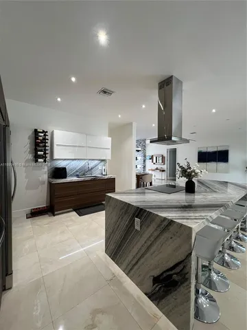 a kitchen with stainless steel appliances a sink a stove a microwave a refrigerator and cabinets