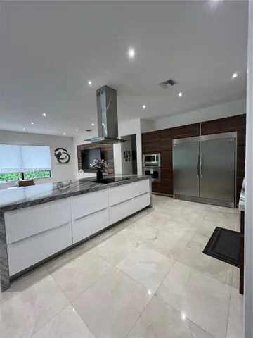 a large white kitchen with a large window