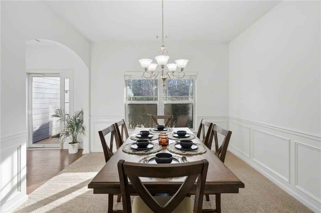 246 Manous Way Canton, GA 30115 - Photo 11 of 38 a dining room with furniture a chandelier and wooden floor
