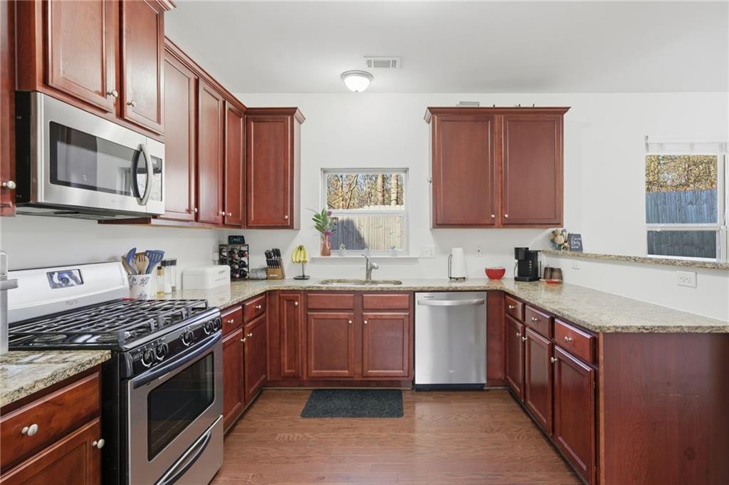 246 Manous Way Canton, GA 30115 - Photo 2 of 38 a kitchen with stainless steel appliances granite countertop a stove a sink dishwasher and a refrigerator