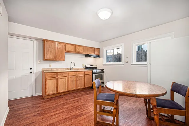a kitchen with a table chairs sink and cabinets