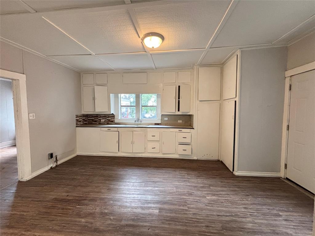 3024 Bonham Street Paris, TX 75460 - Photo 5 of 13 a view of a kitchen with a sink and dishwasher a refrigerator with wooden floor