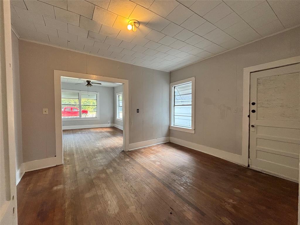 3024 Bonham Street Paris, TX 75460 - Photo 8 of 13 an empty room with wooden floor and windows