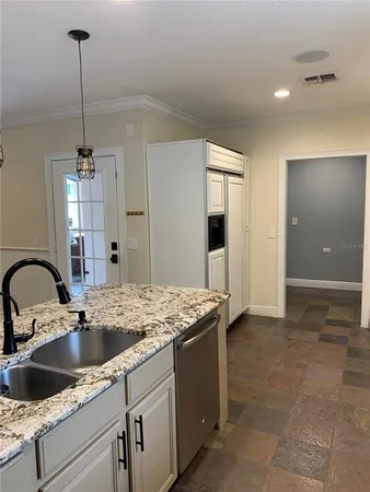 a kitchen with a sink a counter space and a refrigerator
