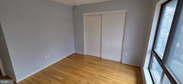 a view of empty room with wooden floor