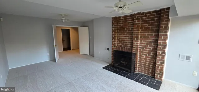 a view of an empty room with a fireplace and a window