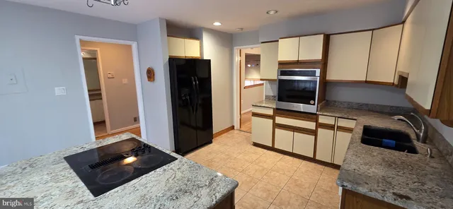a kitchen with stainless steel appliances kitchen island granite countertop a refrigerator stove and oven