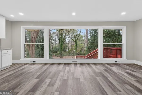 an empty room with wooden floor and outdoor view