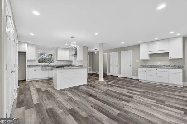 a large kitchen with kitchen island a sink stainless steel appliances and cabinets