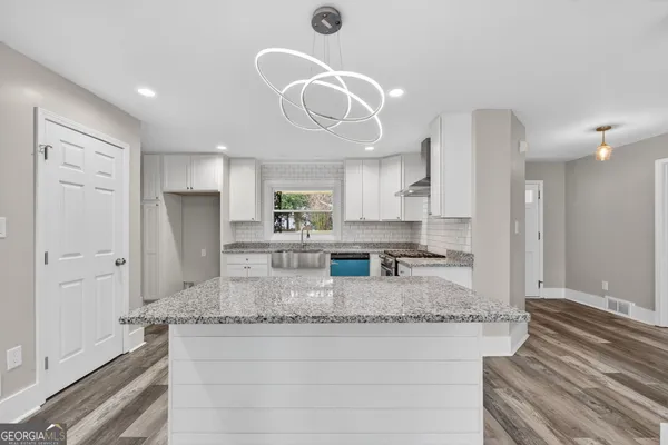 a kitchen with stainless steel appliances granite countertop a sink refrigerator and cabinets