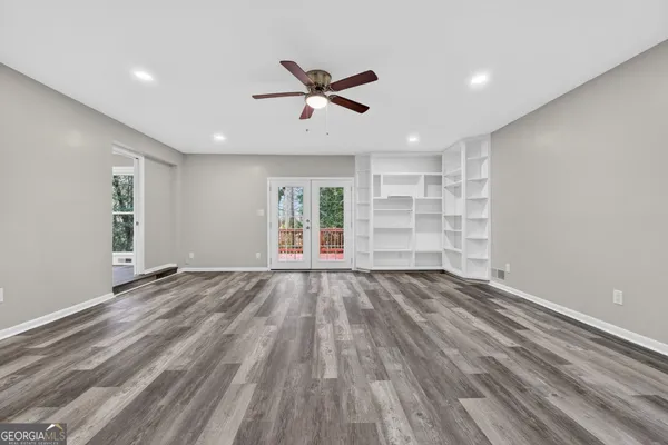 a view of empty room with wooden floor and window