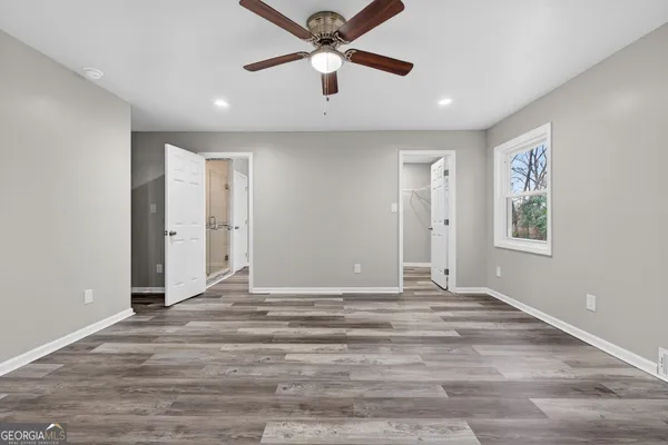 a view of empty room with wooden floor