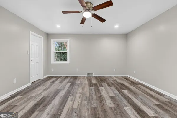an empty room with a window and a ceiling fan