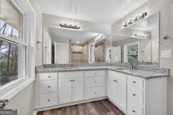 a bathroom with a granite countertop sink double and mirror