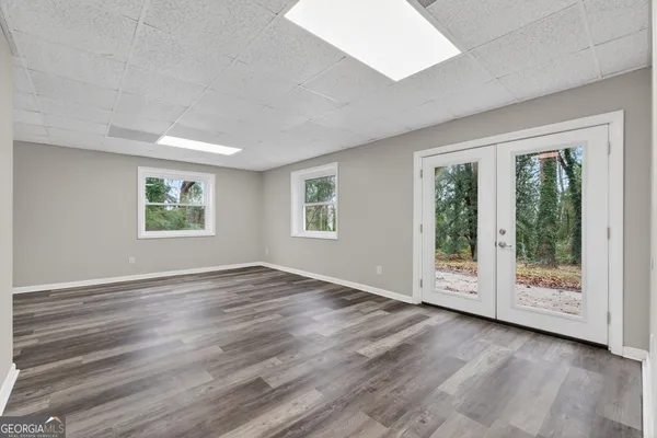 an empty room with wooden floor and windows