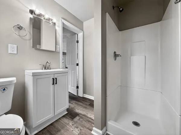 a bathroom with a sink a toilet and shower