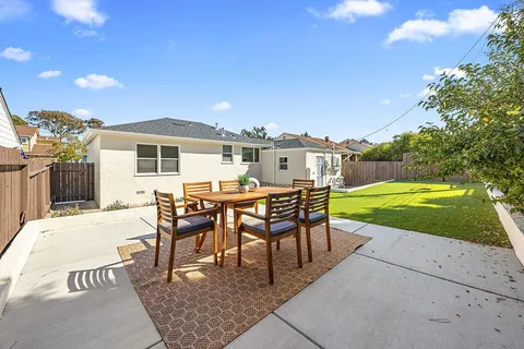 a view of a patio with table and chairs floor to ceiling window with wooden fence