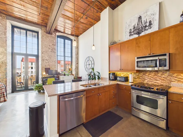 a kitchen with stainless steel appliances a sink a stove and a microwave