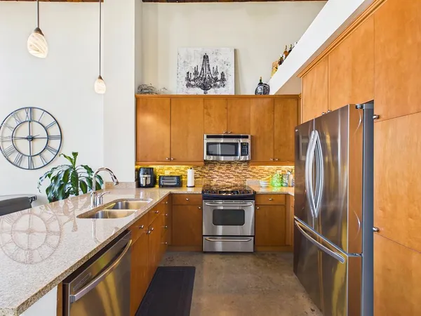 a kitchen with stainless steel appliances a sink stove and refrigerator