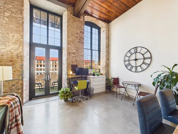 a living room with furniture a chandelier and a large window