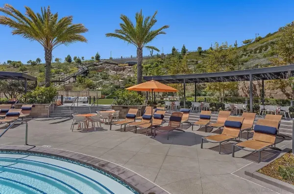 a view of a patio with a table and chairs under an umbrella with a fire pit