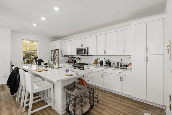 a kitchen with white cabinets sink and stove