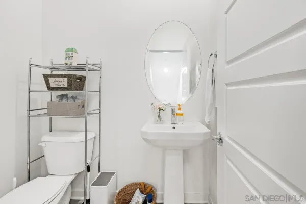 a bathroom with a sink toilet and mirror