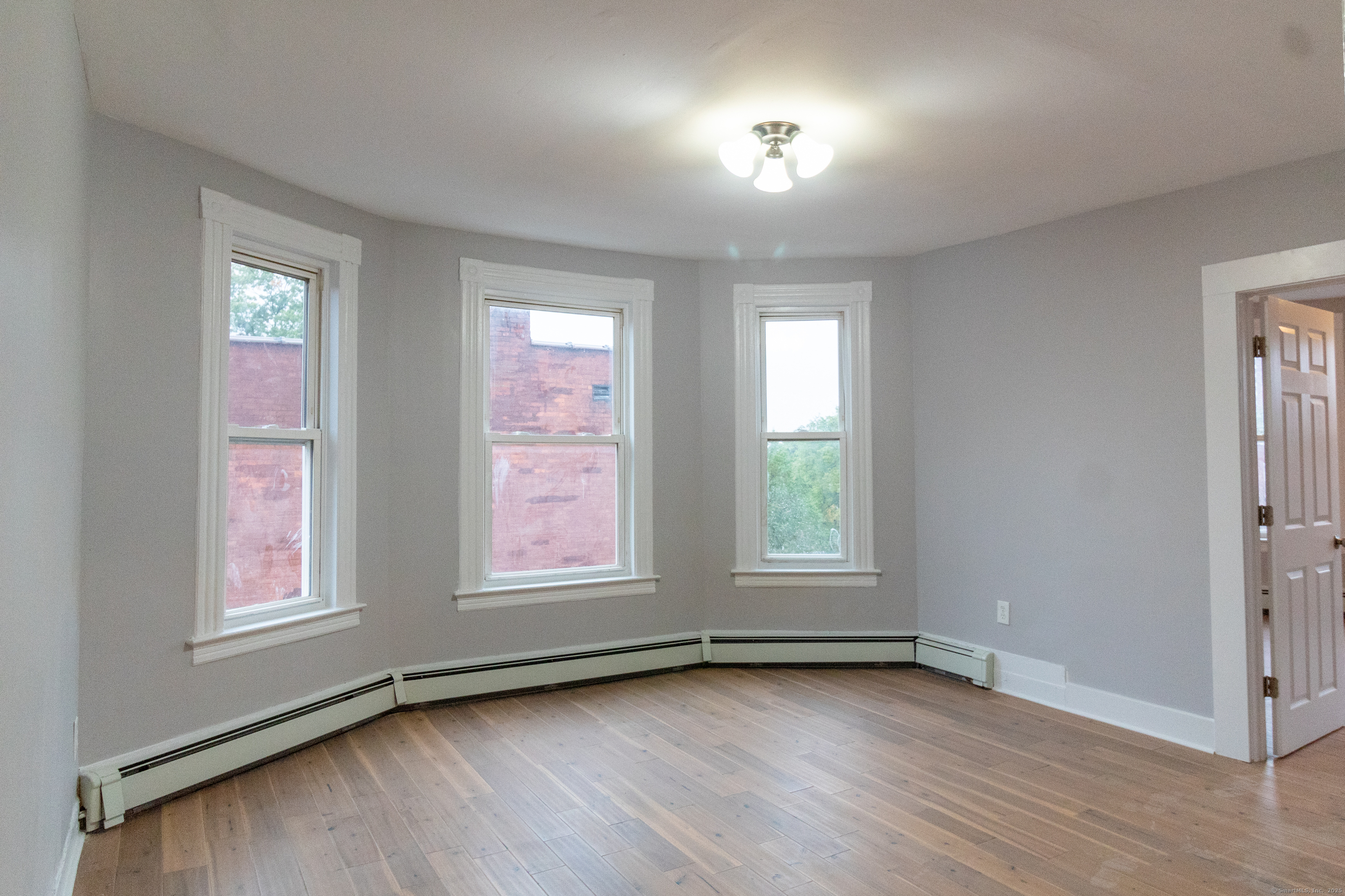 43-45 York Street, Unit 2 Hartford, CT 06106 - Photo 5 of 10 an empty room with wooden floor and windows