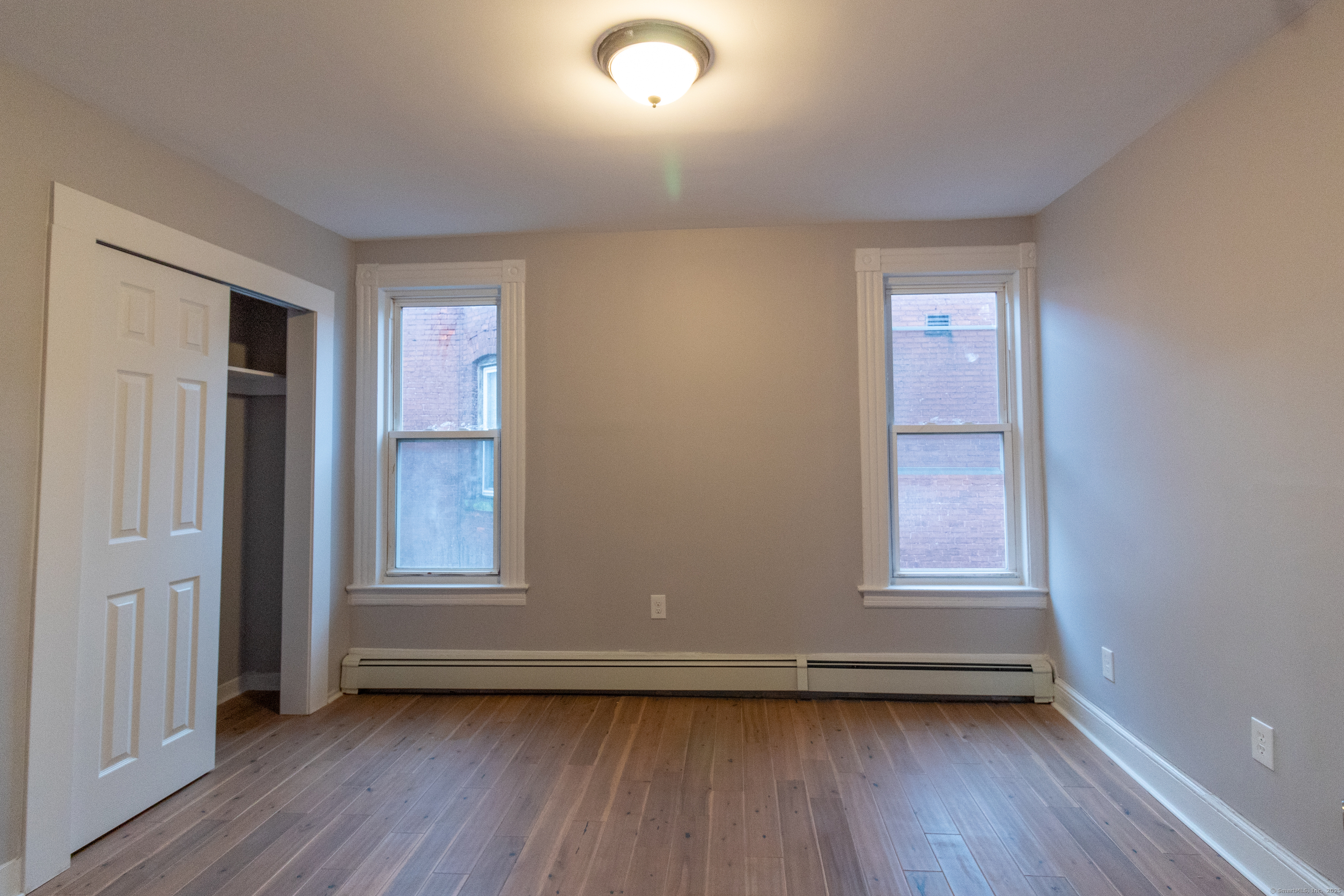 43-45 York Street, Unit 2 Hartford, CT 06106 - Photo 6 of 10 an empty room with wooden floor and windows