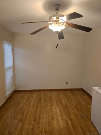 a view of a room with wooden floor fan and window