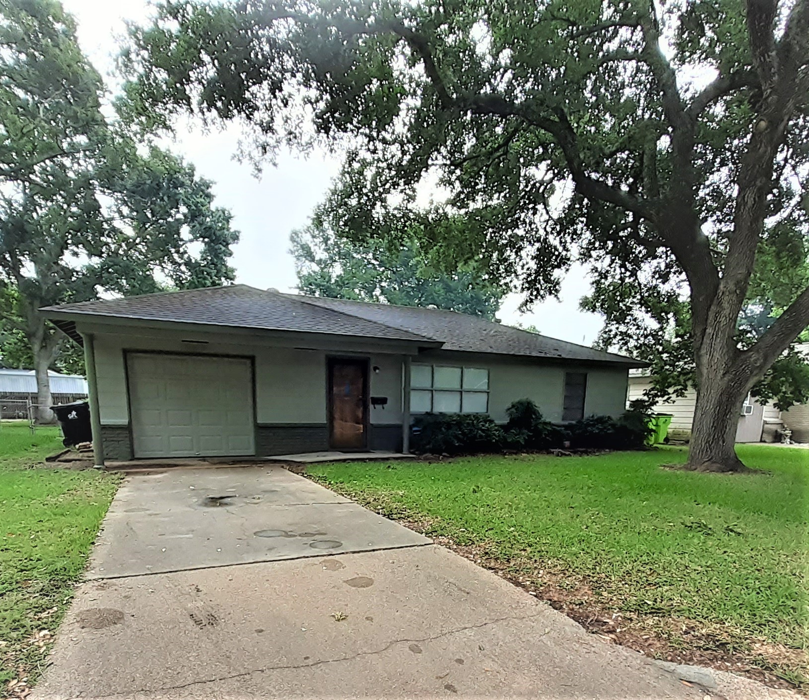a front view of a house with yard and trees